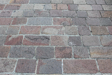 Texture of square cobblestone. Pattern of sidewalk tiles in the street. Cobblestones close up.
