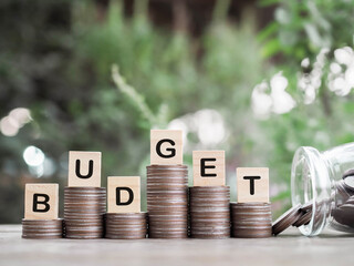 Wooden blocks with the word BUDGET on stack of coins. The concept about budget planning and...