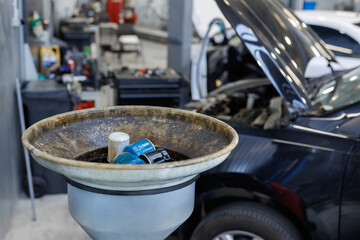 Used oil filters. A bowl for draining old engine oil in the garage workshop.