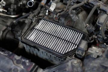 Auto mechanic checking, cleaning and replacing car air filter. Concept of car care service maintenance.