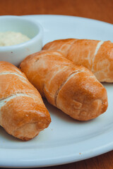 tequenos served on plate with garlic sauce, Venezuelan food