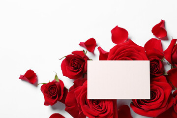 Blank card, beautiful red roses and petals on white background, flat lay. Space for text