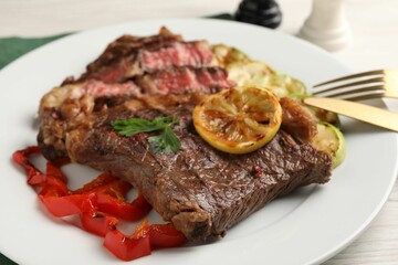 Delicious grilled beef steak and vegetables on table, closeup