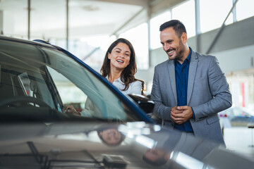 Shot of a young couple looking at cars at a car dealership. I think we can both agree that this is the car for us. Visit to the dealership.