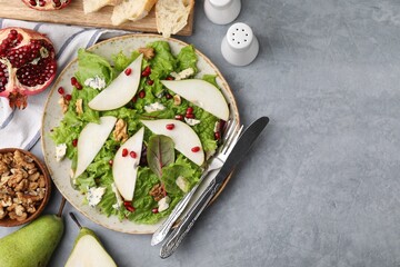 Delicious pear salad served on grey textured table, flat lay. Space for text