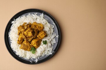 Delicious chicken curry with rice on beige background, top view. Space for text