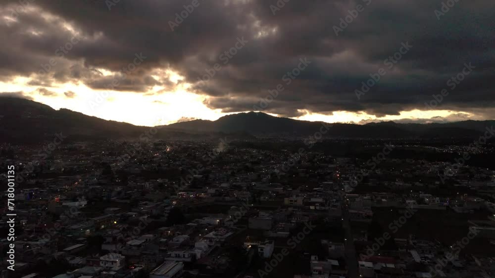 Canvas Prints Aerial cityscape view over the buildings of Quetzaltenango at sunset with dark clouds in Guatemala