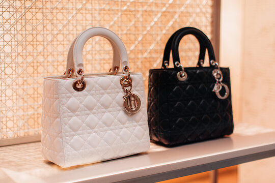 Black and white leather Dior handbags with golden logotype. Christian Dior is a French company which owns the high-fashion clothing producer and retailer.