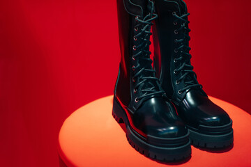 Black women's patent leather lace-up shoes on a boutique stand on a red background