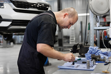The master repairs the gears on the starter of the car. Car repair.