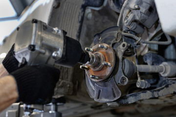 Auto mechanic installing car front brake caliper and brake pads.