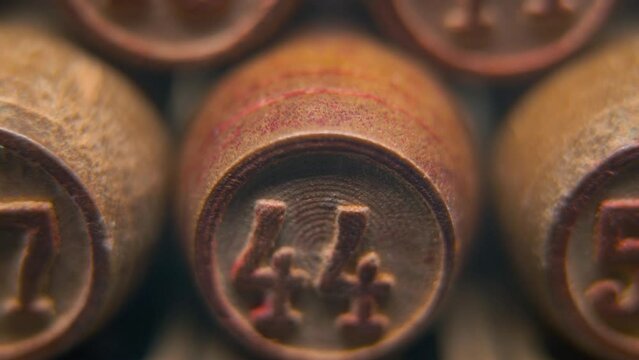 Cinematic macro smooth shot of Bingo wooden barrels in a row, woody figures, old numbers vintage board game, lucky number 44, slow motion, 4K commercial gimbal movement, dreamy lighting, tilt up