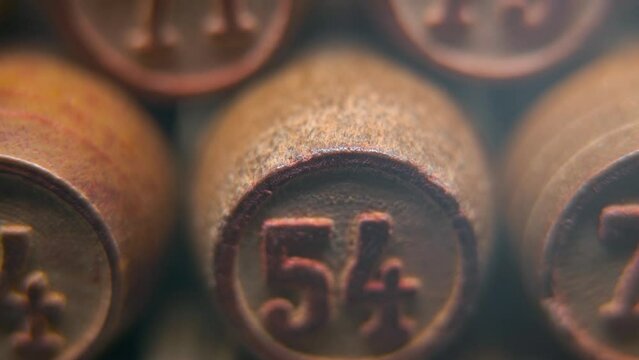 Cinematic macro smooth shot of Bingo wooden barrels in a row, woody figures, old numbers vintage board game, lucky number 54, slow motion, 4K commercial gimbal movement, dreamy lighting, tilt up