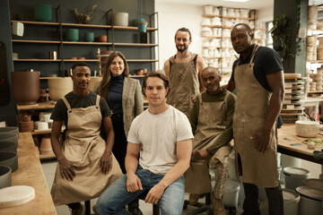 Diverse group of smiling ceramists working in a pottery studio - Powered by Adobe