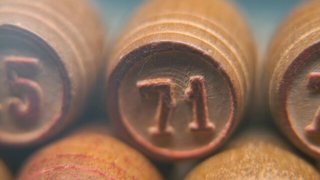 Cinematic macro smooth shot of Bingo wooden barrels in a row, woody figures, old numbers vintage board game, number 75, slow motion, commercial gimbal movement, pan right