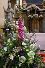 a large bouquet of meadow flowers in a vase in a church