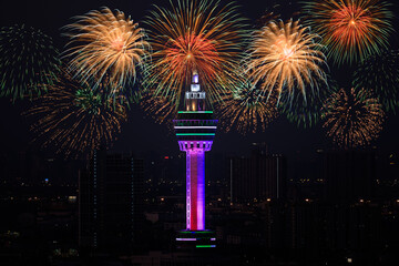 Samut Prakan city hall tower and cityscape over firework at night time