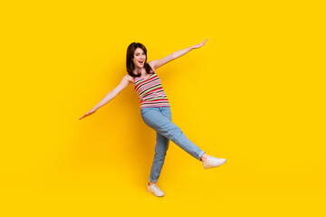 Fototapeta na wymiar Full size photo of pretty adorable woman dressed knitwear top jeans pants holding palms like wings isolated on yellow color background