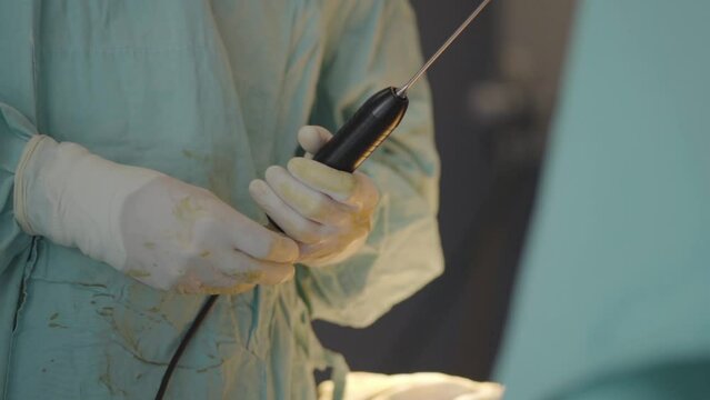 Physician handling a large catheter before surgery, showcasing meticulous preparation and expertise for a comprehensive medical procedure.