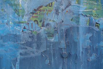 blue wall with torn advertisements