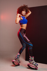 Sporty woman with curly hair in Kangoo jumpers on studio background - 718041304
