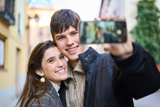 young couple taking a selfie with their smart phone in the city