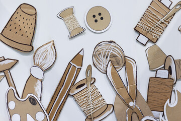 Cardboard items for embroidery on a white wall.