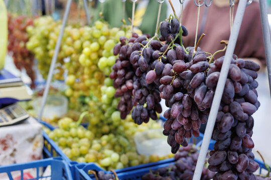 Fresh bunches of grapes ready for sale in wooden box at the farmers market.