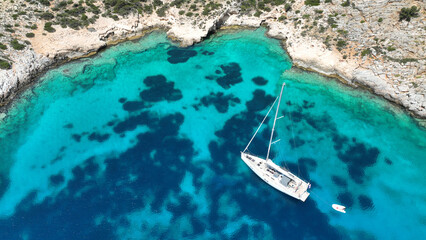 Aerial drone photo of luxury sail boat anchored in paradise bay of Ornos in island of Mykonos,...