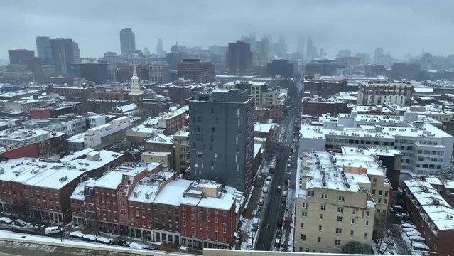 Large American city covered in snow. Aerial shot of urban skyscrapers in USA metropolis on snowy overcast winter day.