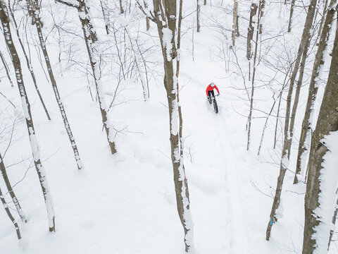 Drone view of a fat biker riding his bicycle in the snow during Canadian winter