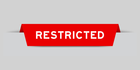 Red color inserted label with word restricted on gray background