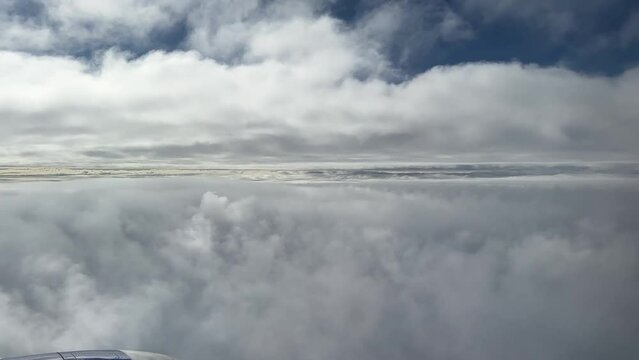 Spectacular Aerial Views Of A Commercial Airplane Flying Between Two Layers Of Clouds; Window Seat Passenger POV.