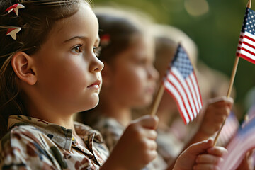 Children holding or waving small American flags during a Memorial Day celebration