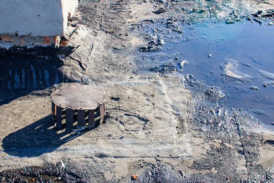 storm drain on a bitumen roof and rain puddles on an old unrepaired roof, the problem of leakage of old housing stock