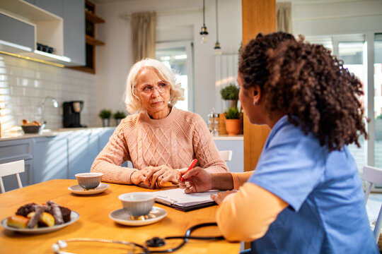 Senior woman talking to caregiver at home