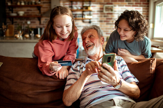 Grandfather and grandchildren online shopping with smartphone at home