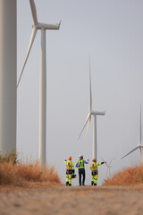 Businessman or investors walk with windmill engineer to audit wind turbine farms, sustainable...