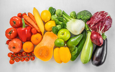 fresh organic fruits and vegetables in rainbow colors on a white background top view