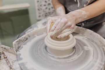 Close up of woman working on pottery at pottery wheel in studio