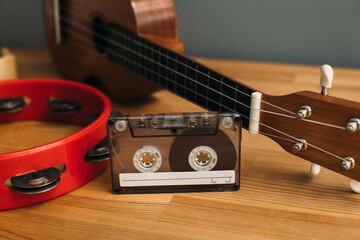 Musical still life with cassette, guitar and tambourine.