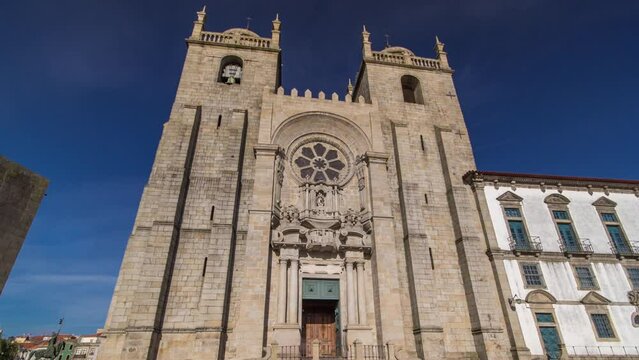 Porto Cathedral or Se Catedral do Porto timelapse hyperlapse front view with blue sky at sunny day. Romanesque and Gothic architecture.