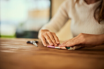 Close-up of a woman using her both hands, to wrap a gift for someone.