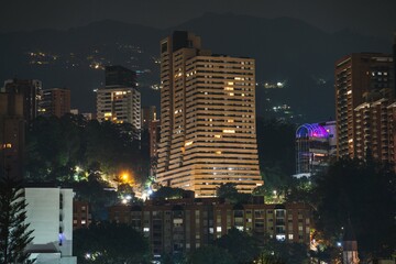 night capture of beautiful building with many windows and balconies in south american city surrounded by mountains