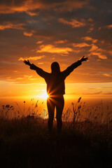 Fototapeta premium silhouette of a woman in sunset in nature with arms spread wide open