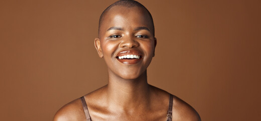 Face, beauty and smile with happy black woman in studio isolated on brown background for wellness. Portrait, skincare and aesthetic for foundation cosmetics or dermatology with a natural bald person - obrazy, fototapety, plakaty