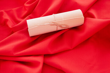 A gift wrap tied with a string on a red background., expensive gift