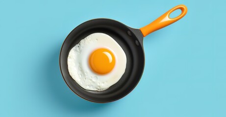 Eggs being fried on a frying pan in the photo on a blue background - obrazy, fototapety, plakaty
