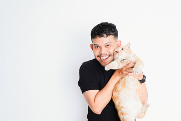 a young asian man hugging a tabby cat, on a white background