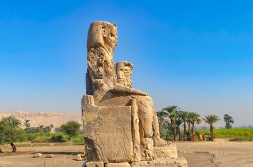 Fototapeta na wymiar Colossi of Memnon, two massive stone statues representing the pharaoh, Luxor, Egypt